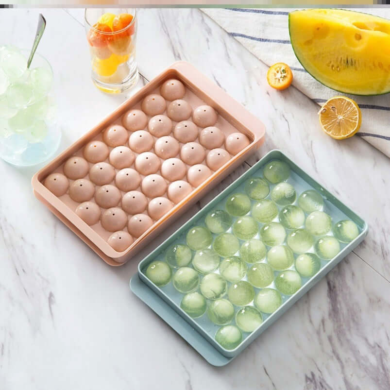 3D round ice cube mold showcasing two trays in pink and blue, perfect for drinks and cocktails.