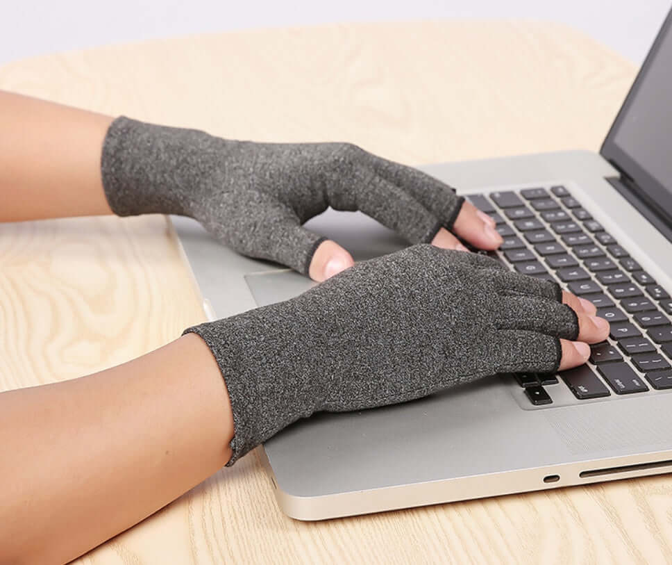 Person wearing Breathable Health Care Half Finger Gloves while typing on a laptop keyboard.